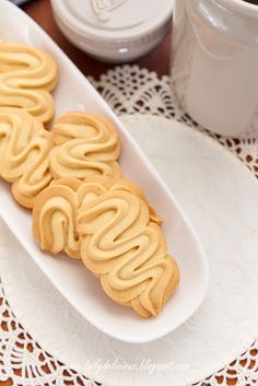 some cookies on a white plate next to a cup of coffee