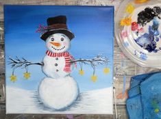 a painting of a snowman with a top hat and scarf next to a plate