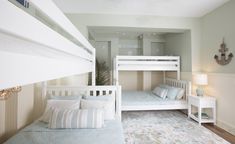 a bedroom with bunk beds and white furniture