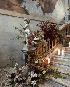 an arrangement of flowers and candles on the stairs