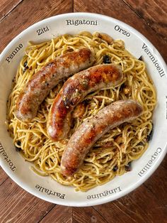 three sausages and noodles in a white bowl