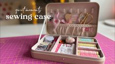 an open suitcase filled with lots of items on top of a pink table cloth covered table