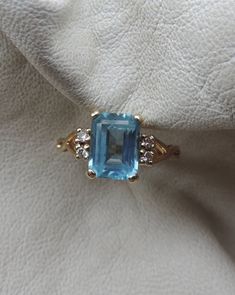 sweetest blue topaz ring - 4 tiny cut diamonds - fine condition - marked carlyle - size 5 - 14k gold - pretty ring - delicate strength - emerald cut cabochon - graceful setting - lovely cocktail ring - vintage 14k ring - timeless refinement Formal Blue Topaz Crystal Ring In Fine Jewelry Style, Luxury Blue Topaz Timeless Ring, Fine Jewelry Blue Topaz Crystal Ring, Aquamarine Cocktail Rings, Topaz Cocktail Ring, Topaz Diamond Ring, Garnet Ring Vintage, Antique Rings Vintage, Diamond Rings With Price