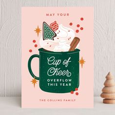 a christmas card with an ice cream sundae in a green mug and the words cup of cheer overflow this year