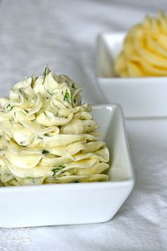 two white bowls filled with food on top of a table