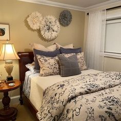 a bedroom with a bed, two lamps and pictures on the wall