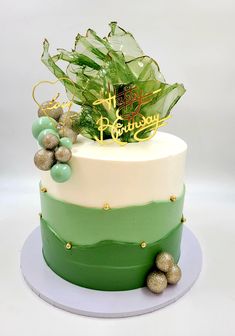 a birthday cake decorated with green and gold decorations