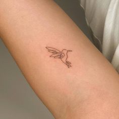 a small hummingbird tattoo on the arm