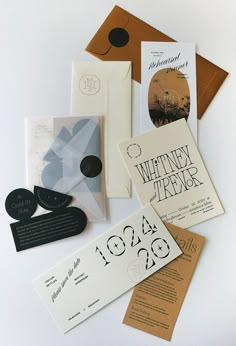 various wedding stationery items laid out on top of each other, including cards and envelopes