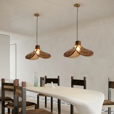 a dining room table with four lights hanging over it