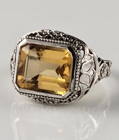 *Size--6 *Weighs-4.2 grams *Genuine, Emerald Cut, Natural Citrine in a solid sterling silver, filigree setting. *Gorgeous floral detailing in the filigree. *Stamped 925. *Dates from the 1990s. *Condition-Excellent for its age. Minor signs of wear & patina.  *Great ornate filigree design typical of the Flapper Era. *Makes a marvelous statement on the finger. *Heirloom quality ring you will enjoy for generations to come! *You will receive the exact item in the pictures. All professional cleaning w Formal Engraved Filigree Ring In Sterling Silver, White Gold Filigree Ring With Gemstone, Formal Engraved Sterling Silver Filigree Ring, Ornate Filigree Wedding Ring Stamped 925, Formal Silver Filigree Ring With Intricate Design, Silver Filigree Ring With Intricate Design For Formal Occasions, Elegant Citrine Rings Stamped 925, Engraved Filigree Ring For Formal Occasions, Victorian White Gold Filigree Ring With Gemstone