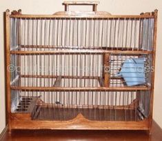 an old wooden birdcage sitting on top of a table next to a wall