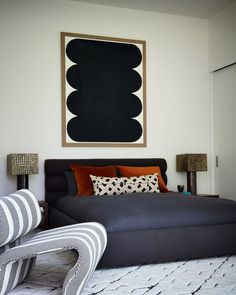 a black and white bedroom with an art piece on the wall