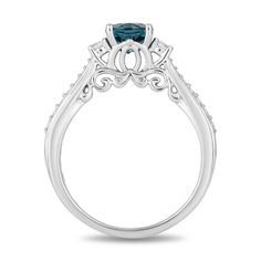 a blue diamond engagement ring with filigrees on the sides and an oval center stone