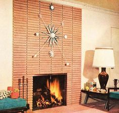 a living room filled with furniture and a fire place in front of a brick wall