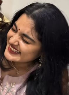 a woman smiles as she brushes her hair