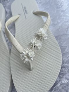 Bridal flip flops are wrapped with ivory satin ribbon and the straps are decorated with three ivory floret's. Ribbon color is ivory if you are needing other colors of ribbon or decoration please contact me and will be happy to accommodate you! All flip flops are handmade to order and the production time is 5-7 business days and then please allow additional time for shipping.  Also available in children size. Amazing for beach, weddings, flower girl or a fancy event, you choose! Please choose you White Sandals For Summer Ceremonies, White Summer Ceremony Sandals, Summer Bridal Accessories For Bridal Shower, White Summer Bridal Accessories For Bridal Shower, Summer White Bridal Accessories For Bridal Shower, White Bridal Accessories For Summer Bridal Shower, White Open Toe Flip Flops For Wedding, Adjustable White Sandals For Beach Wedding, Adjustable Summer Bridal Accessories