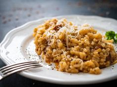 a white plate topped with macaroni and cheese covered in grated parmesan