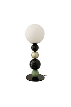 a black and white lamp with three balls on it's base next to a light bulb