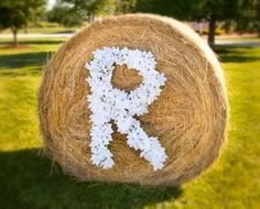 the word r is made out of hay and flowers on top of a bale