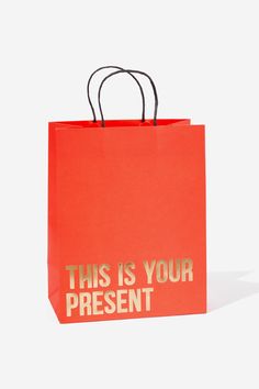 a red shopping bag that says, this is your present