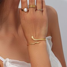 For all our mystic babes out there. This Gold Snake Wrap Bracelet features a slithering snake design that wraps around your wrist creating an elegant yet edgy allure. DETAILS & SIZE Finish: 18k gold plate Materials: 316L Stainless Steel Measurements: Circumference: 8" (can be shaped to fit smaller or larger wrists); Width: 5mm Waterproof, tarnish-resistant, and nickel free Shop Bracelets for more options to layer this with! Elegant Gold Snake Ring, Elegant Adjustable Metal Snake Ring, Elegant Adjustable Snake Ring, Elegant Snake Shape Bangle Perfect For Gift, Elegant Snake-shaped Chain Bracelet Gift, Elegant Snake-shaped Bangle For Gift, Elegant Snake Shape Bangle Gift, Elegant Flexible Snake-shaped Bracelet, Elegant Snake-shaped Bangle As Gift