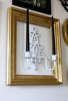 a white candle holder sitting on top of a wooden shelf next to a framed photograph