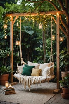 a white swing chair with pillows and lights hanging from it's sides in the middle of a garden