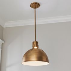 a light fixture hanging from the ceiling in a room with white walls and flooring