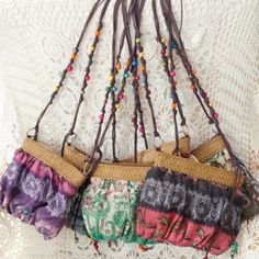 three purses are hanging on a lace doily