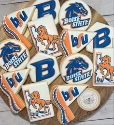 decorated cookies with the boise state logo on them are arranged on a wooden platter