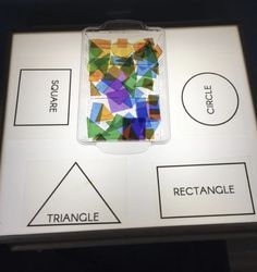 a display case with different shapes and words on the front, along with an image of a cell phone