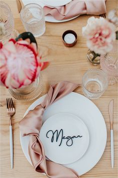 the table is set with plates, silverware and napkins that say mr and mrs