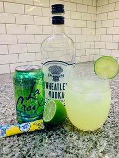 a bottle of whine next to a glass with lime