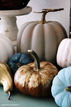 several different colored pumpkins sitting on a table