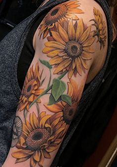 a sunflower tattoo on the arm and shoulder