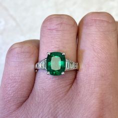 This stunning gemstone ring features a green cushion cut natural emerald, GIA-certified as 2.48 carats with great saturation. The emerald is prong-set in 18k white gold. Tapered baguette cut diamonds adorn the shoulders of this ring.
The total approximate diamond weight in this ring is 0.53 carats. The center emerald measures 9.36mm x 7.67mm x5.46mm.
If you have any questions about our Madison Ring, please contact us. Luxury Green Cushion Cut Emerald Ring, Cushion Cut Emerald Ring For Formal Occasions, Cushion Cut Emerald Green Rings, Green Cushion Cut Emerald Ring With Accent Stones, Classic Green Emerald Ring With Accent Stones, Classic Baguette Cut Green Emerald Ring, Classic Green Baguette Cut Emerald Ring, Classic Emerald Ring With Tsavorite Accent Stones, Fine Jewelry Emerald Cushion Cut Ring