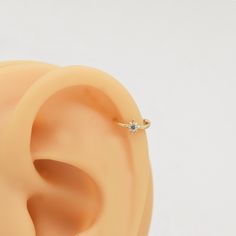 an ear is shown with a single diamond in it