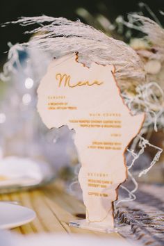 a table with plates and silverware on it, including an africa map cut out of wood