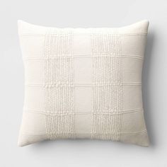 a white pillow on a gray wall with a black and white checkerboard pattern