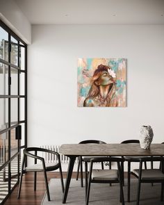 a dining room table with chairs and a painting on the wall above it that has a woman's face