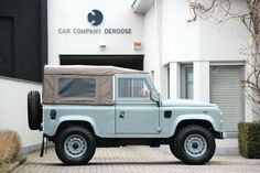 a white land rover parked in front of a building