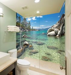 a bathroom with rocks and clear blue water