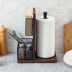 kitchen utensils are sitting on a counter next to a paper towel dispenser