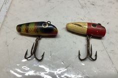 two fishing lures sitting next to each other