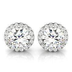 pair of diamond stud earrings with round halos and pave set in 18k white gold