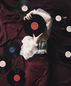 an overhead view of a woman holding up records