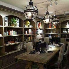 a computer desk sitting under two hanging lights