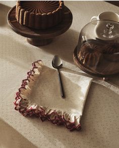 a table topped with cakes and desserts on top of a white cloth covered table