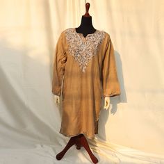 Discover the epitome of elegance with our Plain Beige Brown Base Color Kurti Shirt, adorned with exquisite machine embroidery. The detailed patterns around the shoulders and neck create a charming contrast to the solid beige outfit, featuring stunning embroidery. Made from high-quality, soft pashmina, this top ensures comfort and style for the summer and spring seasons. Its detailed embroidery and graceful patterns make it a perfect choice for semi-formal and formal events. Embrace versatility with this article, pairing it effortlessly with simple jewelry and statement shoes for various occasions. Ideal for both indoor and outdoor use, each uniquely crafted piece is available in limited quantity and sizing, ensuring you stand out with exclusivity and finesse. Product specifications: Base c Traditional Long Sleeve Embroidered Dress, Long Sleeve Embroidered Dress For Eid, Long Sleeve Floral Embroidered Dress For Eid, Festive Long Sleeve Kaftan With Dabka Work, Intricate Embroidered Long Sleeve Dress For Eid, Intricate Embroidery Long Sleeve Dress For Eid, Long Sleeve Embroidered Dress For Traditional Ceremonies, Festive Multicolor Embroidered Long Sleeve Dress, Long Sleeve Embroidered Dress For Festive Season